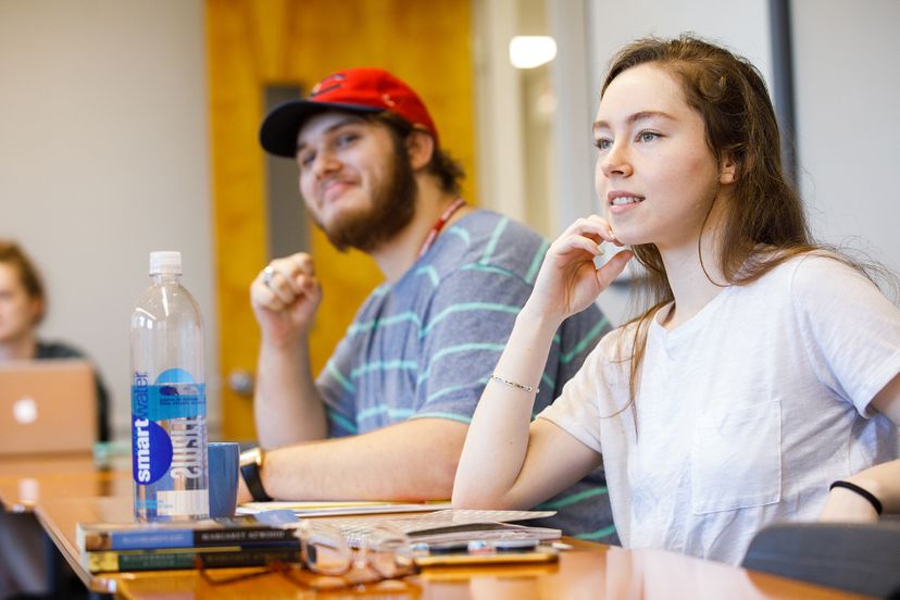 Male Student and Female student in class smiling