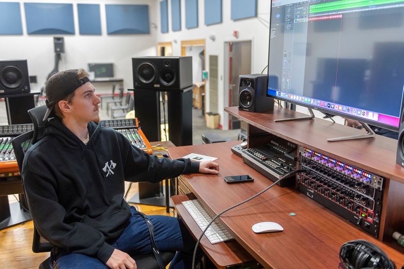 Music student in studio at sound panel
