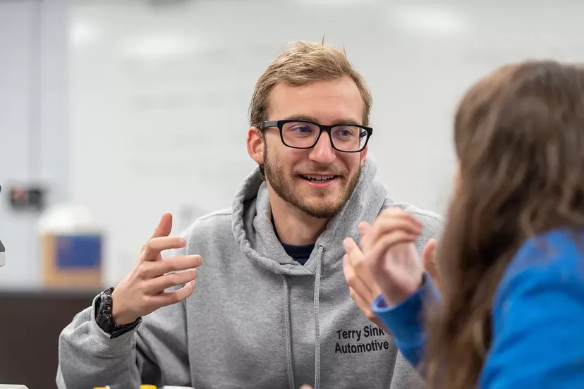 Male student talks to female student in class