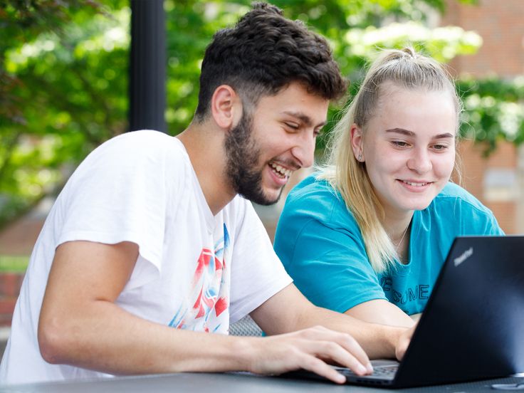 Catawba College students outside on a laptop